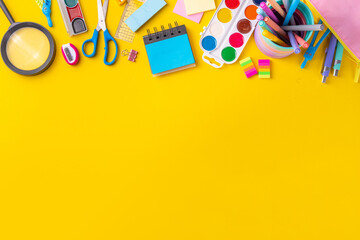 School equipment high-colored bright yellow flat lay. Various school education and office supplies,...