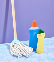 Detergents and a mop with a white floor mop on a purple background.