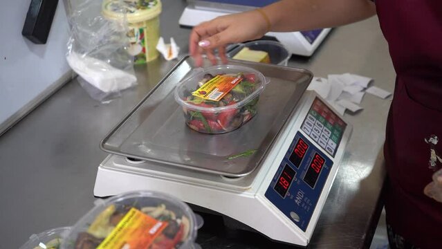 pakking the vegetable salad with a weighing machine