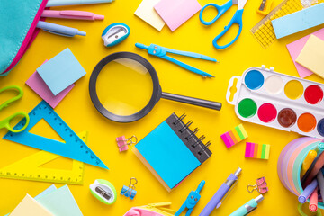 School equipment high-colored bright yellow flat lay. Various school education and office supplies,...