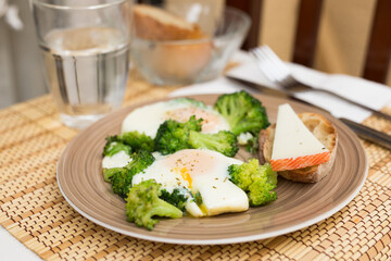Breakfast of crumpled eggs with broccoli