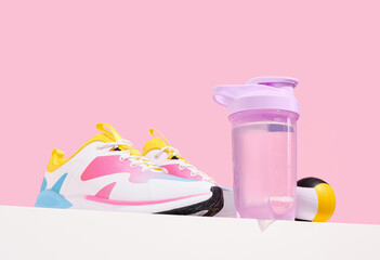 Fitness concept. Sports sneakers, shaker with water and ball.