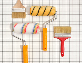 Different paint rollers and paint brushes on table. Renovation concept, flat lay.