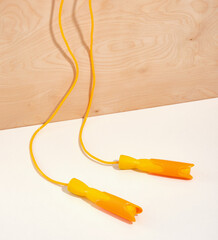 A bright yellow long jump rope for exercise and weight loss. Exercise in a gym or at home.