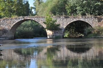 Fototapeta na wymiar The historical stone bridge built over the meander river