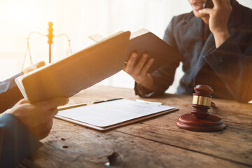 team of lawyers is reading legal revision of the law book to understand and learn the laws that...