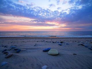 Obraz premium Sonnenuntergang an steinigem Strand