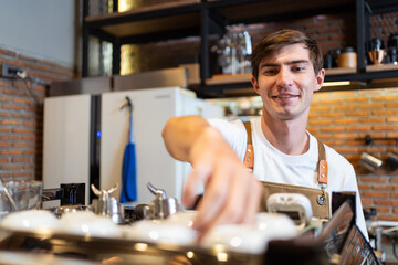 Professional caucasian coffee barista making a cup of coffee by using a modern espresso machine.