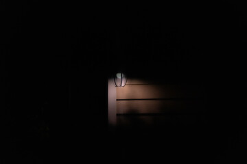The light that shone in front of the dim building at this dim time was scary.