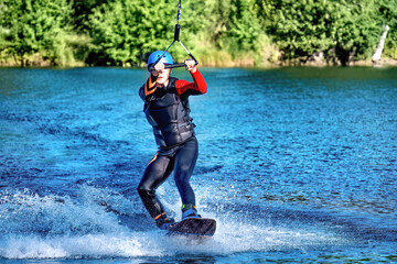 Wakeboarding on the sea on summer day in life jacket. Soft focus. Action blur.