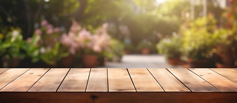 An outdoor garden background with a wooden table top that is empty and blurred. The wood table provides space for text, marketing promotions, or any other content. It is a blank space that can be