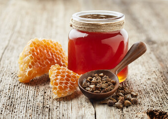 Propolis with honey on old wooden background