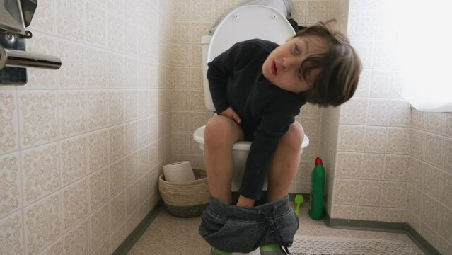 One cute little boy sitting on toilet seat. child doing his hygiene needs