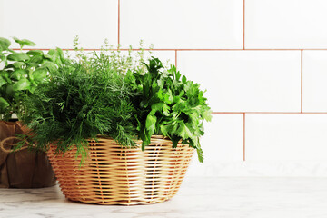 A basket full of fresh herbs on the kitchen table.