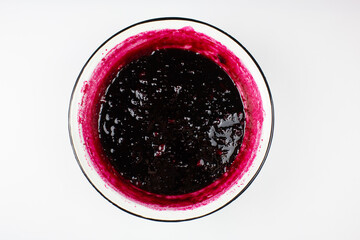 Blackcurrant jam on a white background.Red jam in a metal bowl.