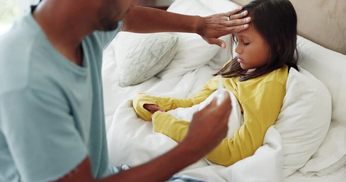 Sick, thermometer and father checking his kid for a fever in bed with a cold, flu or allergies. Illness, recovery and dad feeling the head temperature of his girl child in the bedroom of their home.