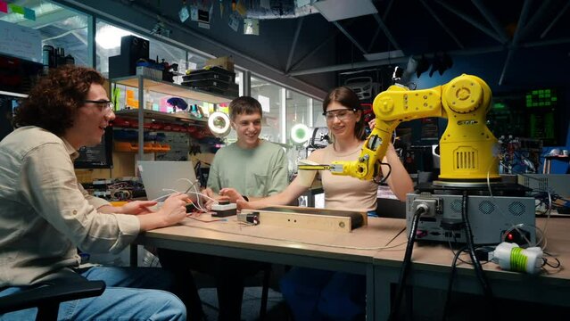 Group of young people doing experiments in robotics in a laboratory. Robots and tools on the table