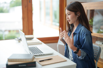 Happy asian woman speak conference on laptop in video call people smart working from home.