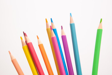 Different colors pencils - card with drawing stationery on white background, art education