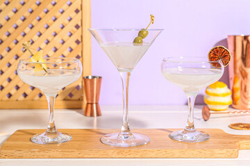 Board with glasses of martini on table