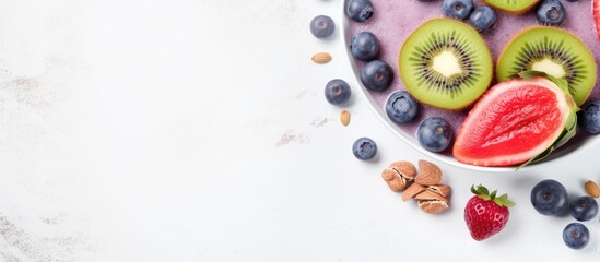 Naklejka na ściany i meble Make a smoothie bowl with Pink Berry, topped with granola, kiwi, and blueberries. The background is light gray, and space for adding text.