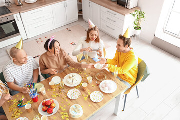 Group of young friends celebrating Birthday in kitchen