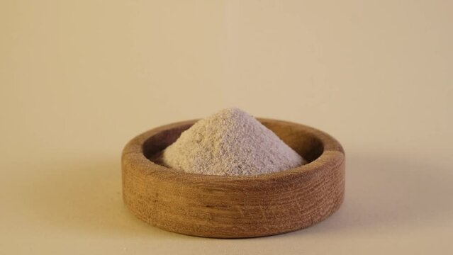 Psyllium flour poured into wooden plate, close-up. Video, slow motion. Crushed Psyllium (Ispaghula) seeds and husk. Natural food supplement to aid weight loss. Dietary Fiber. Low carb diet.