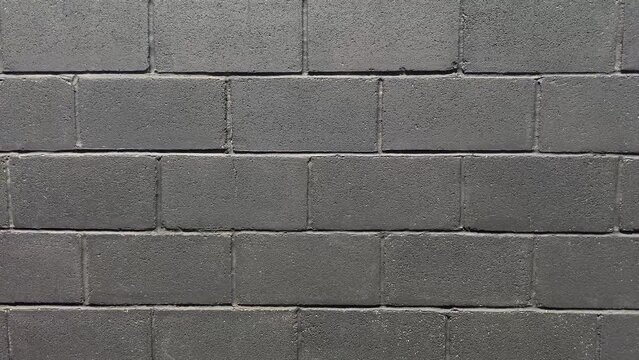 Texture background of black outside wall in shape of bricks.