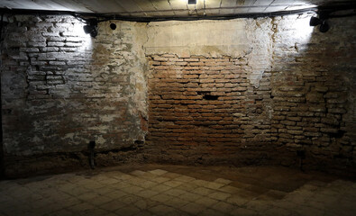 Spooky basement with pipe. red brick wall and wet tiled floor. Building under construction red...