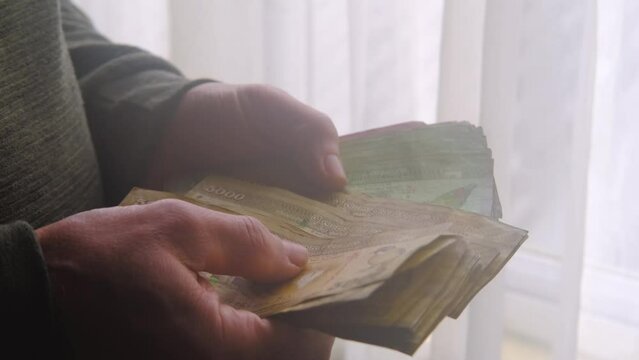 man holding, counts lot of national currency of Sri Lanka, paper money bills Rupee banknotes, devaluation, high inflation of state, exchange rate on travel, vacation, savings, banking, tax payment