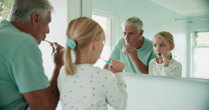 Grandfather, grandchild and brushing teeth, mirror and dental, morning routine in bathroom and hygiene. Toothbrush, cleaning mouth and grooming, old man and young girl at home, health and bonding