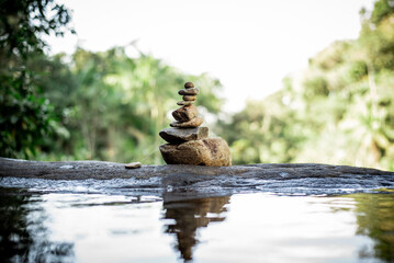Natural Harmony: Pebbles in Equilibrium by a Calming Waterfall