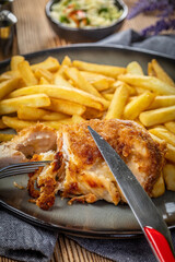 Fried chicken breast stuffed with bacon and cheese served with chips and salad.