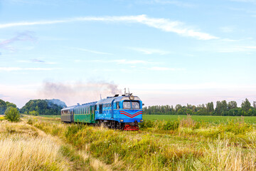 A narrow-gauge diesel locomotive with a passenger train is going to Gayvoron station. Ukrainian railways.