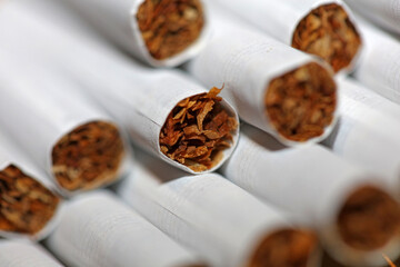 Many cigarettes in colorful background close up of a roll tobacco in paper with filter tube no smoking concept image of several commercially made cigarets pile non smoking campaign tobacco