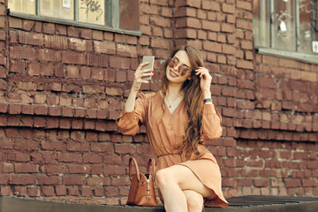 Woman using smartphone screen as mirror