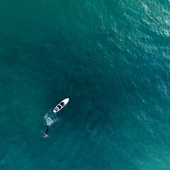 Imagen aérea de un nadador y tabla de surf en el mar de Rosarito, México - obrazy, fototapety, plakaty