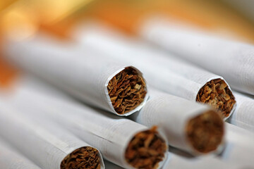Many cigarettes in colorful background close up of a roll tobacco in paper with filter tube no smoking concept image of several commercially made cigarets pile non smoking campaign tobacco