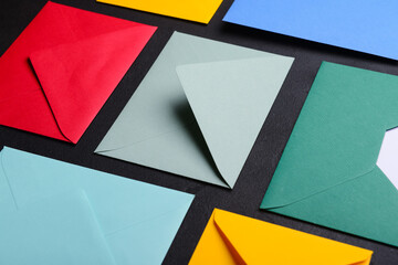 Composition with colorful envelopes on dark background, closeup