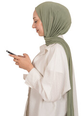 Using smartphone, side view profile portrait of young muslim caucasian girl in hijab using smartphone. Smiling, looking mobile phone screen. Messaging, typing, scrolling, browsing social media.