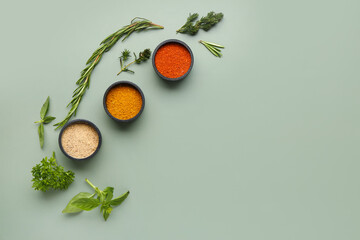 Composition with bowls of fresh spices and herbs on color background