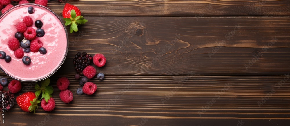 Poster A view from the top with copy space showing a raspberry smoothie and a bowl of berries on a wooden table.