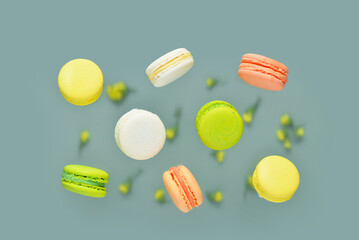 Flying sweet macaroons on green background