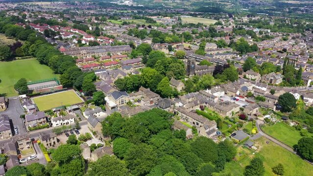 Aerial drone footage of the beautiful village of Almondbury in Huddersfield in the UK, showing a birds eyes view of the British village and housing estates in the summer time