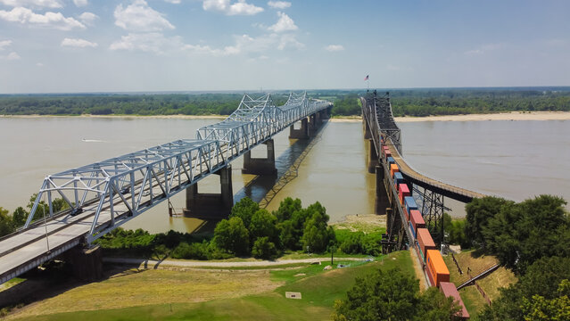 Vicksburg Bridge and Old Vicksburg Bridge with freight train crossing all-steel railroad truss river carrying Interstate 20, U.S. Route 80 across the Mississippi River sunny cloud sky