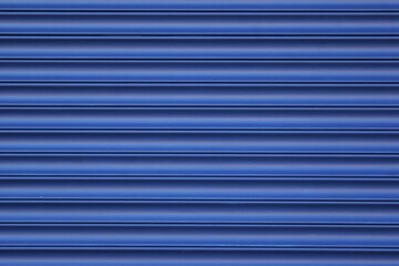 Roller blinds and garage gates. Closed metal shutter casements close-up. Background of blue...