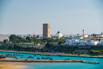 Fototapeta premium Oud Bou Regreg with fishing boats with Hassan Tower and Mausoleum of Mohammed V, Rabat, Morocco