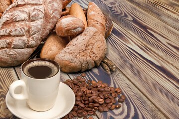 Fresh soft bread and cup of coffee on wood table