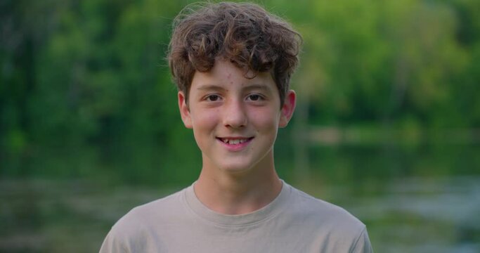 Slow motion portrait of cheerful teenager and smiling outdoors. People and emotions concept.