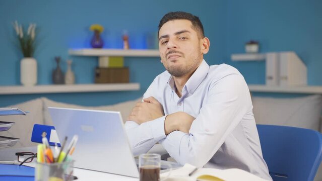 Home office worker man looking smugly at camera.